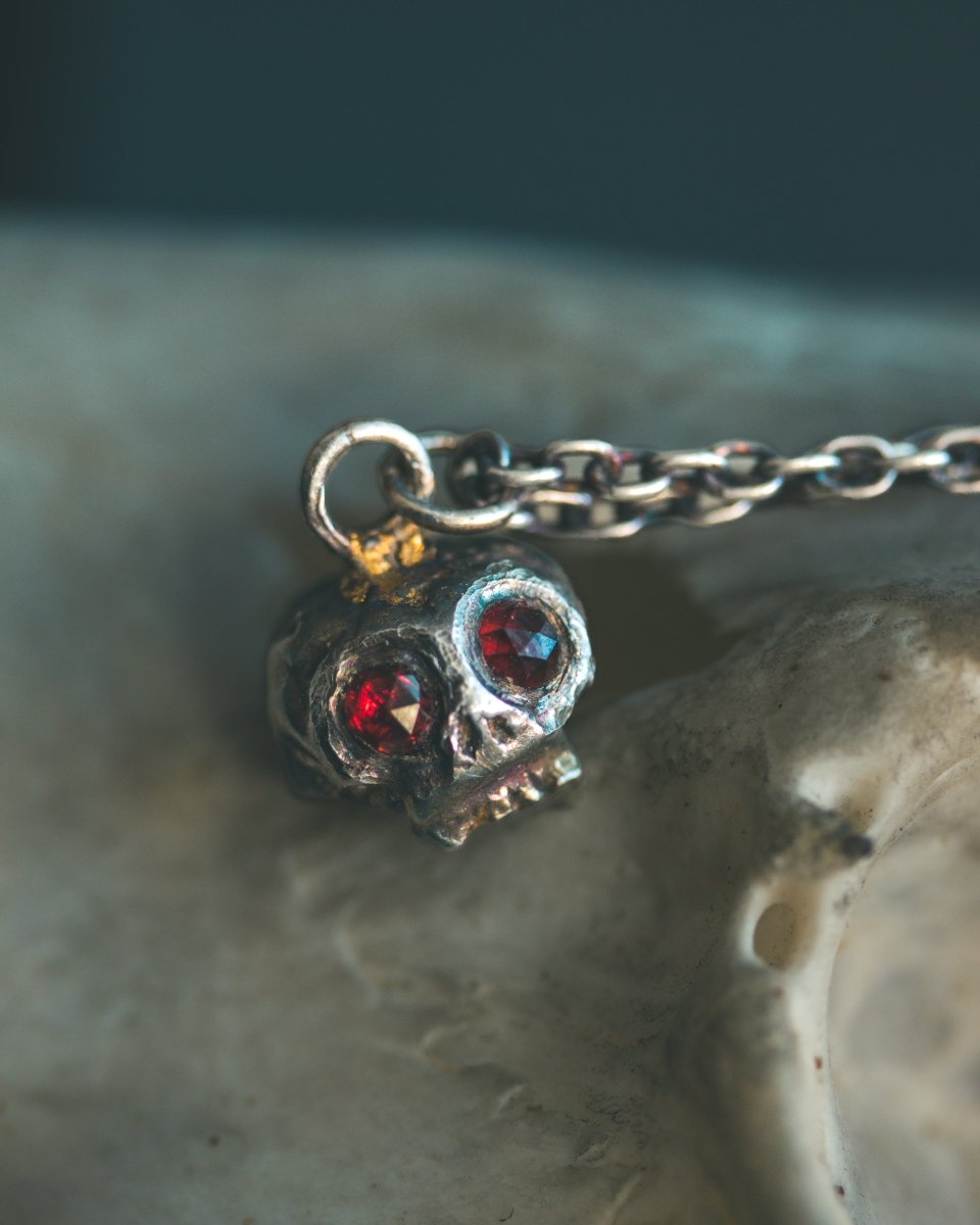 Memento Mori Skull Charm with Almandine Garnet Eyes – Sterling Silver & 23.5K Gold | Talisman of Life, Death, and Deep Transformation - Machinations