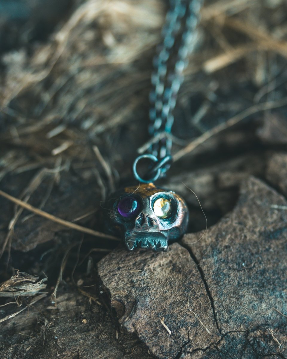 Memento Mori Skull Charm with Peridot and Amethyst Eyes: A Tribute to Life’s Duality and the Spirit of Beetlejuice (Limited Edition) - Machinations
