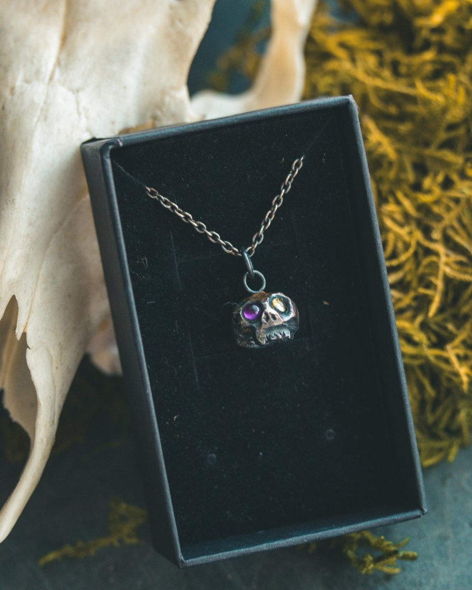 Memento Mori Skull Charm with Peridot and Amethyst Eyes: A Tribute to Life’s Duality and the Spirit of Beetlejuice (Limited Edition) - Machinations