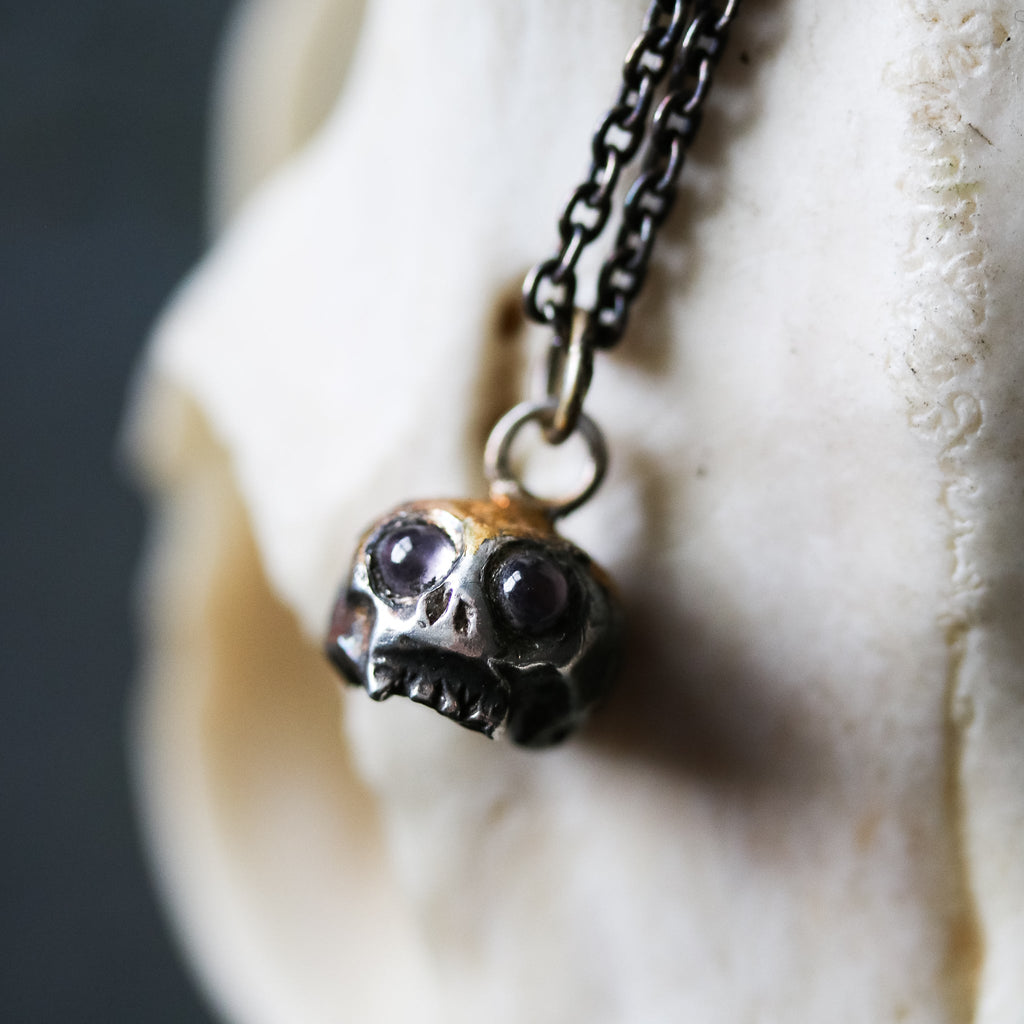 Skull charm with amethyst eyes - Machinations